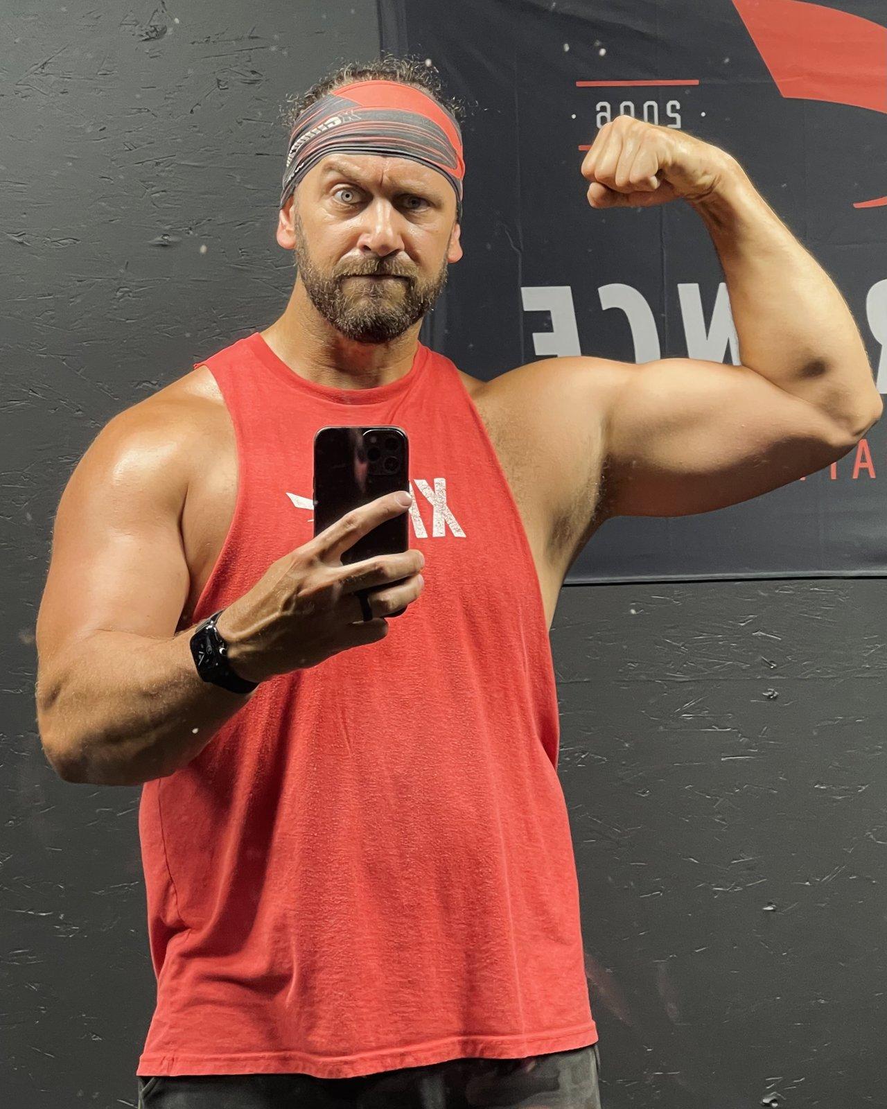 Big Mike Behrens flexing in his gym