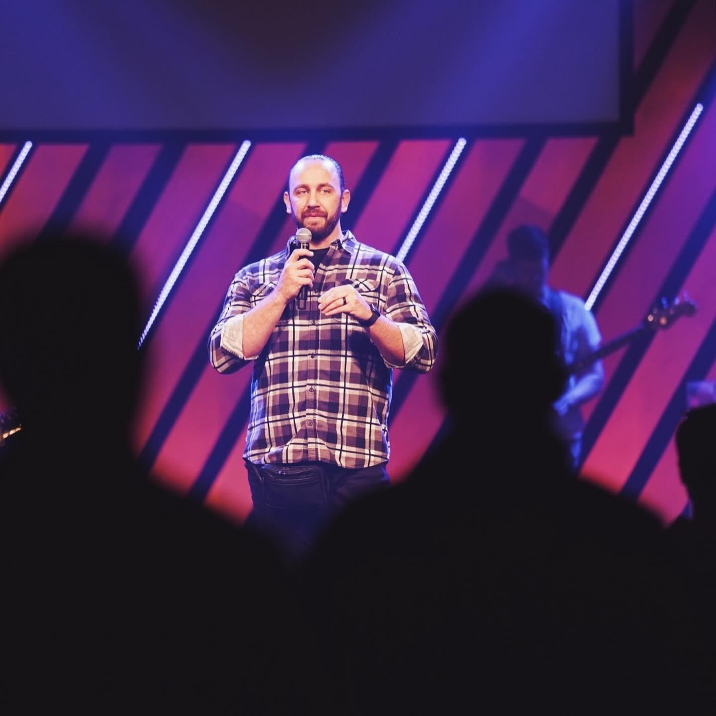 Mike Behrens speaking on stage at church